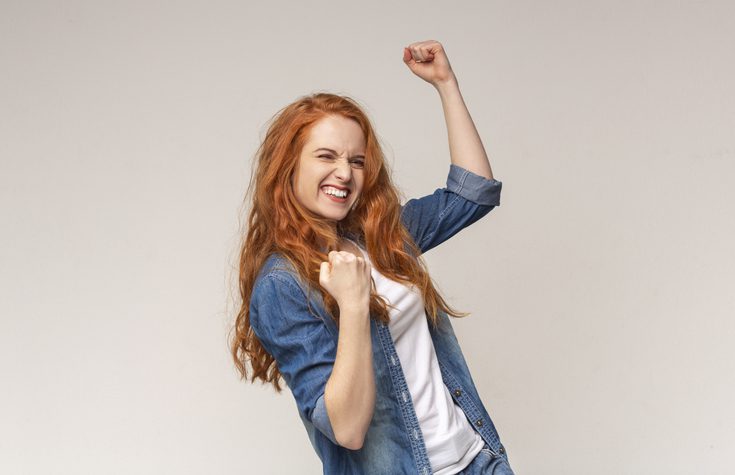 Chica sonriente celebrando un éxito