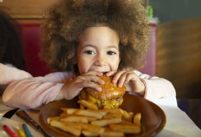 Niña comiendo una hamburguesa