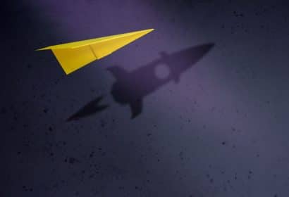 Avión de papel con un cohete en la sombra