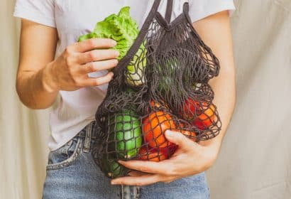 Chica sosteniendo bolsa de tela con verduras