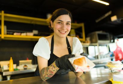 Camarera sirviendo una hamburguesa gourmet