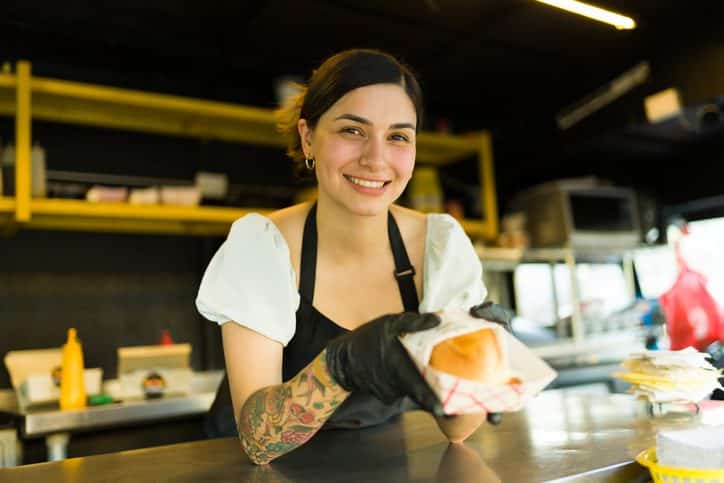 Camarera sirviendo una hamburguesa gourmet