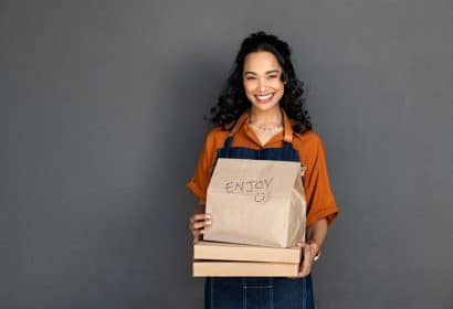 Mujer sonriente con un pedido de comida a domicilio