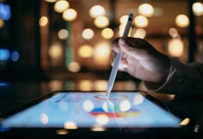 una mano señala con un lapiz sobre una tablet